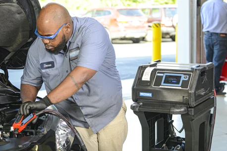 Technician using Midtronics diagnostic charger to test a car battery
