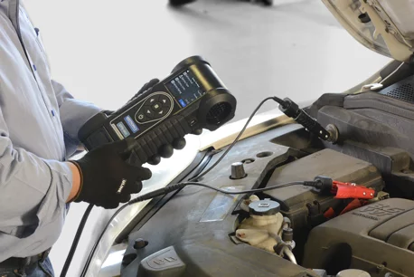 Technician using Midtronics battery tester to test a car battery